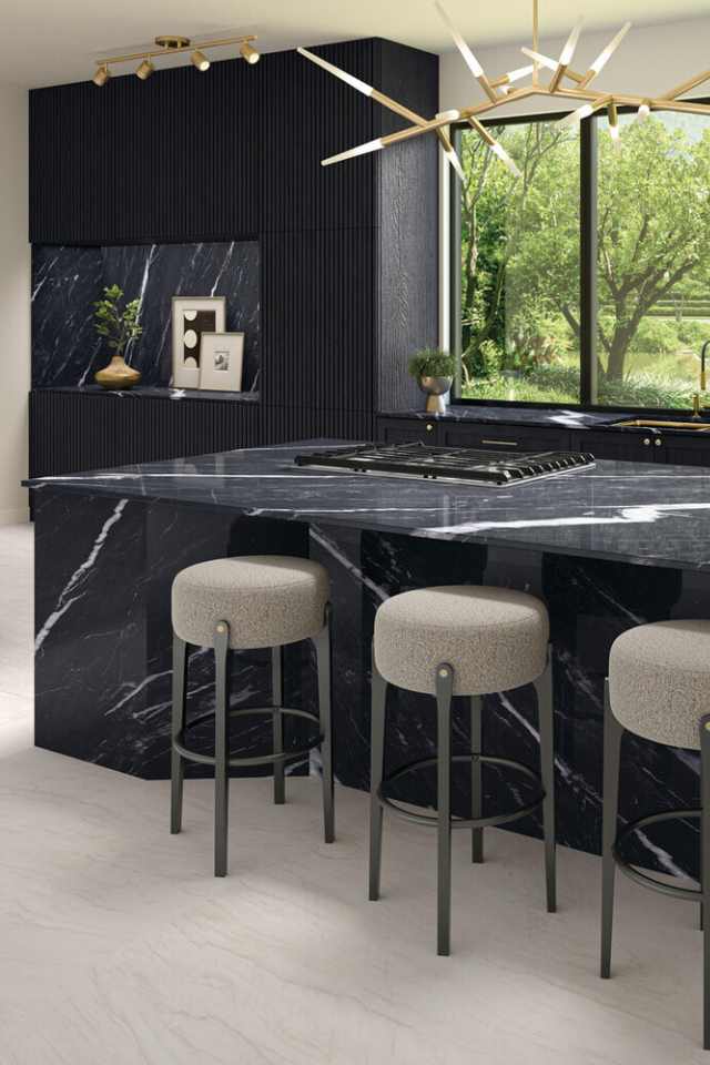 natural slate tile flooring in modern kitchen with black marble countertops and backsplash and gold accent lighting